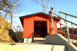 階段の上にある赤い本殿を写した写真