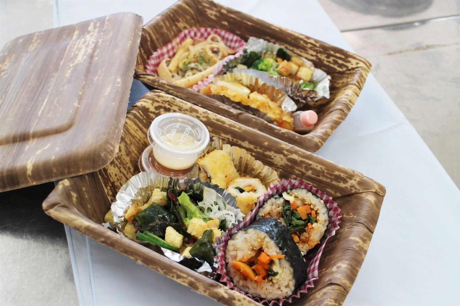 2つの弁当箱が並び、ホヤチーズキンパ、野菜炒め、卵焼きなどのおかずが詰められている写真