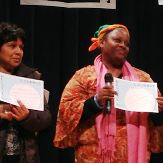 外国の女性2名が『わたしコミット』の用紙を持って舞台に上がっている写真