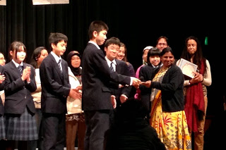 外国の方や学生、いろいろな人が集まって記念撮影をしている写真