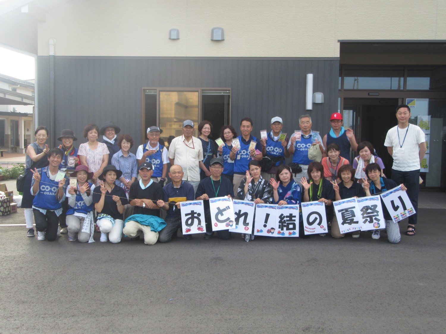 前列の方が「おどれ！結の夏祭り」と書かれたパネルを持って写っている関係者達の集合写真