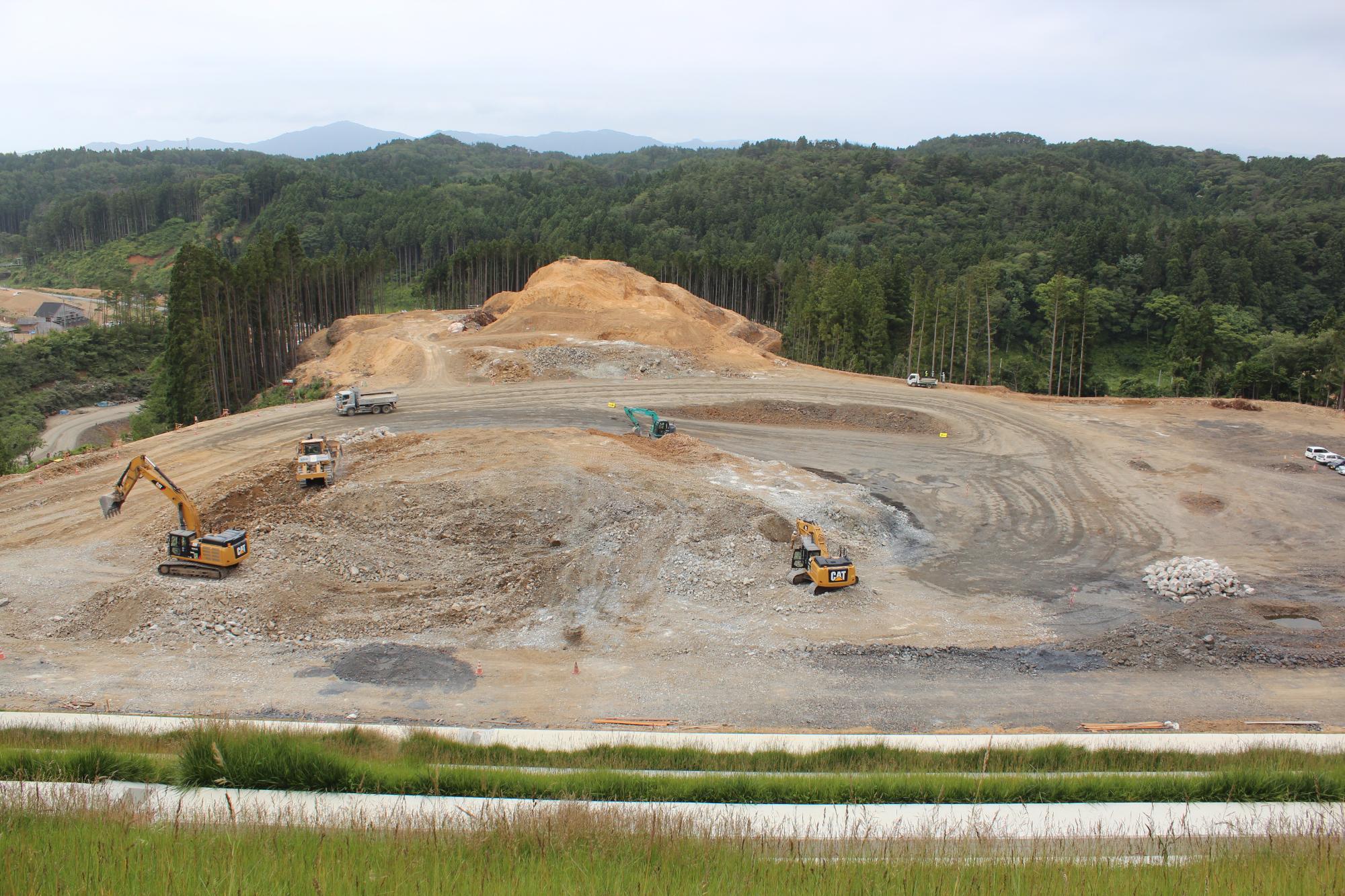 重機やトラックがフル稼働し工事が進められている造成中の現場の写真