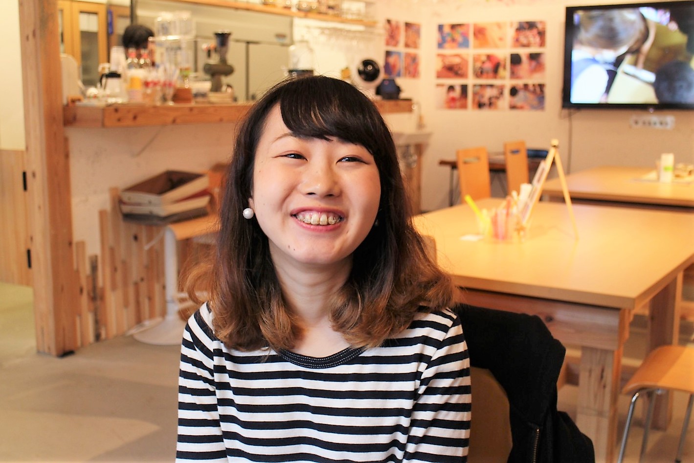 白黒のボーダーの服を着た笑顔の松尾さんの写真