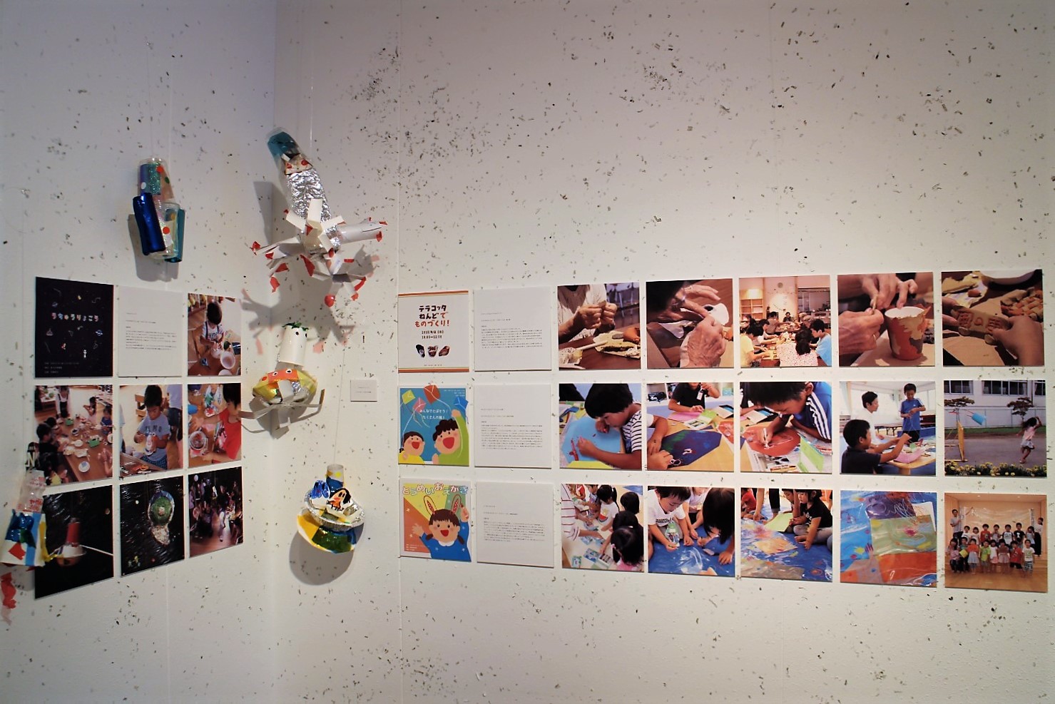 白い壁には作業する子供達の写真や作品が飾られた写真