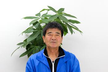 青いパーカーを着て笑みを浮かべている留野さんの写真