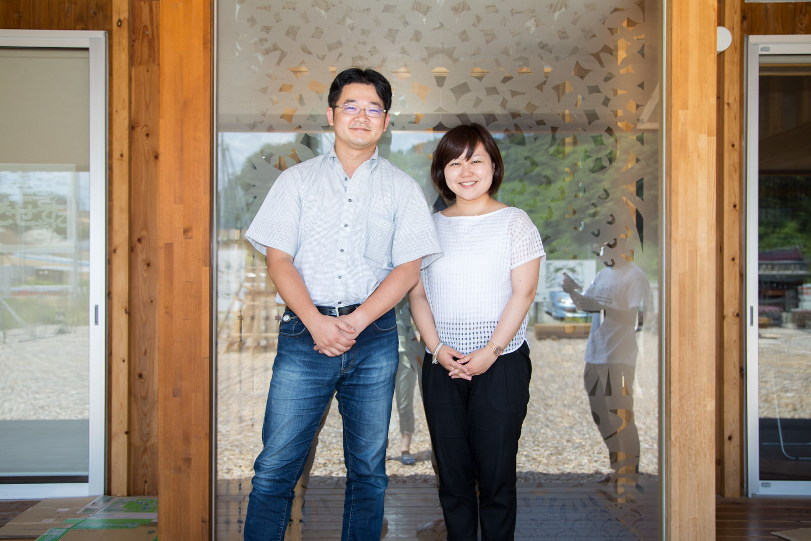 模様が入った大きなすりガラスの前に並んだ後藤さんとリポーターの女性の写真