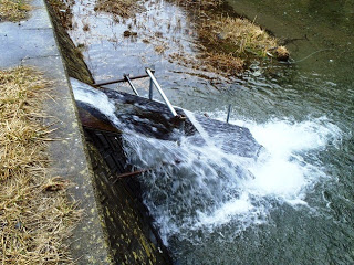 水が上から下へ滑り台のような傾斜を伝って流れ白く泡立つ様子が見えており、その途中には鉄製の格子や柵のような構造が取り付けられている様子を写した写真