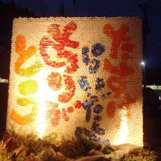 夜にライトアップされた巨大なパネルに「ありがとう」など感謝のメッセージがカラフルな文字で描かれている作品の写真