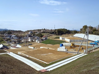 土地が平坦に整えられ、コンクリートの土留めや水路が整備され、宅地として整った区画が並ぶ写真