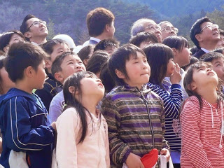 上のほうを向きながら子供たちが並んでいる写真