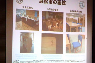 浜松市内の役所や学校などで使われている木製家具の写真が6枚並んだスライドをプロジェクターで映している写真