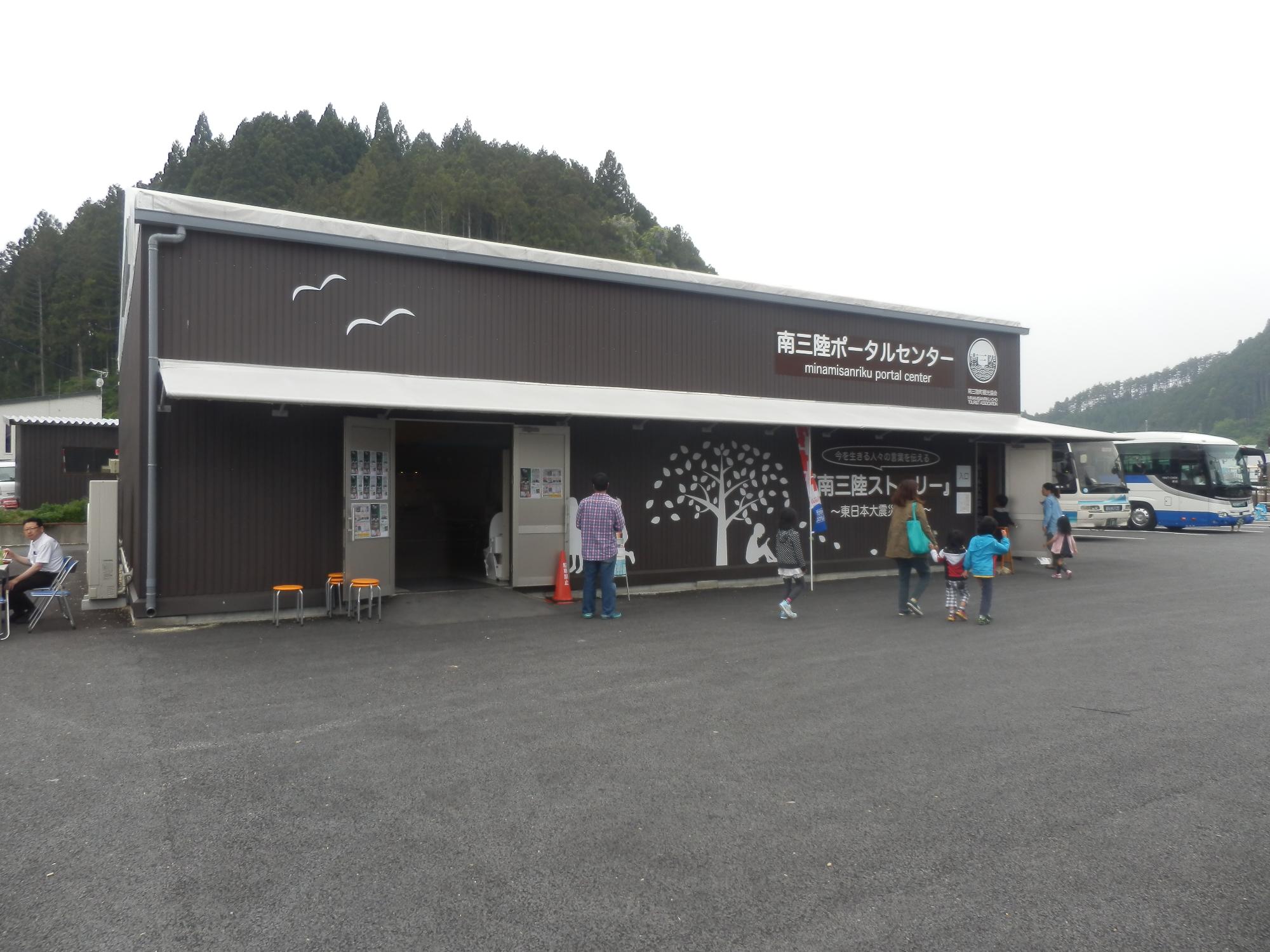茶色の外壁に鳥や木などが描かれ、正面には「南三陸ポータルセンター」と書かれた建物の外観写真