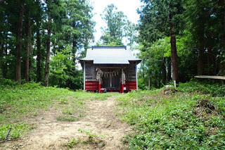 注連縄や鈴がかけられている小さな木造の拝殿が杉林の中にあり、厳かな雰囲気の神社を正面から撮影した写真