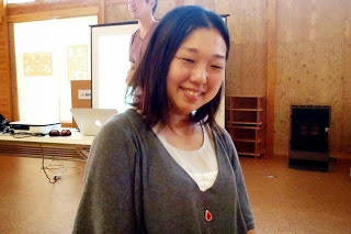 灰色のカーディガンを着た女性が優しく笑っている様子をアップで撮影した写真