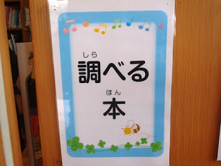 壁に「調べる本」と書かれた案内プレートが貼られている写真