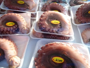 パック詰めされたタコの足がたくさん並んでいる様子の写真