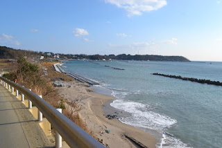 道路沿いの砂浜に波が打ち寄せている写真