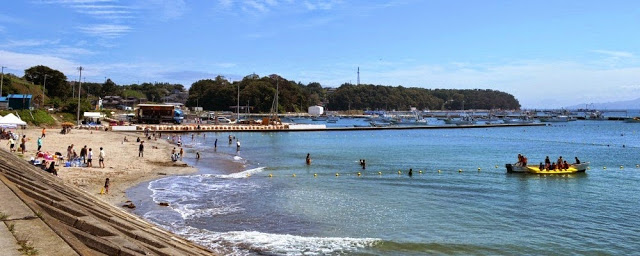 浜辺には人が集まり、海ではバナナボートのような遊具で遊ぶ人たちの姿もあり、ビーチでの遊びを楽しんでいる写真