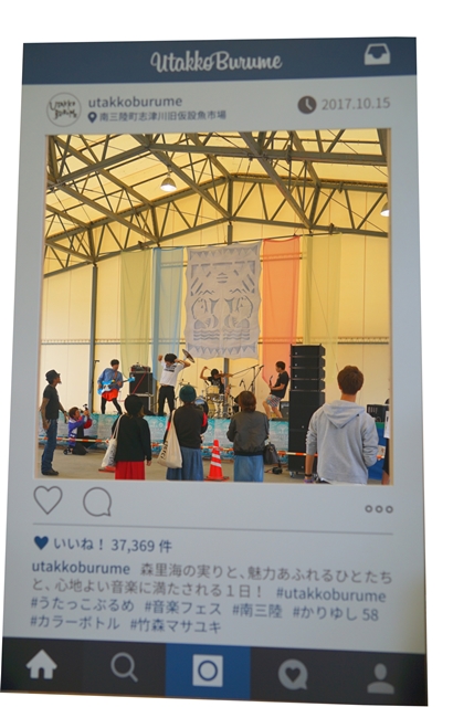 屋内会場のステージでバンドが演奏しており、観客が周囲に集まっている様子が写る、音楽フェスの様子をアップしたSNS画面の写真