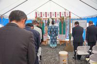 参加者全員が頭を少し下げて起立し、祭壇の前で宮司が祝詞を読み上げている様子を後方から撮影した写真