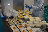 台の上に盛り付けられたうどんや、天ぷらなどが並べて置かれている写真