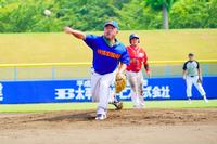 青いユニフォームのピッチャーが力強くボールを投げている写真