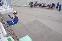 消防士がロープを使って建物から降下する訓練を見守る子どもたちの写真