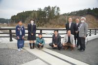 橋に設置された「未来橋」の橋名板の左側に小学生と女子高校生、右側に市長と関係者の方々4名が並んで記念撮影をしている写真