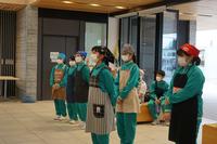 6人のジャージ姿にエプロンを付け、頭にバンダナを巻いた中学生たちが横一列に並び、そのうちの1人の女子生徒が1歩前に出ている写真