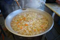 人参や白菜などが入った大量の煮込み料理がぐつぐつ煮える大鍋の写真