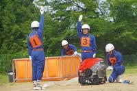 「1番」と「3番」の団員が腕を上げて合図を出している、動作確認中の訓練の写真