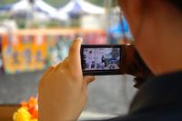 観客がステージの様子をカメラの液晶画面に映し出し、撮影している写真