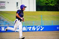 紺色のユニフォームの野球選手が全力でベースに向かって走っている写真