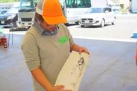 魚拓をとった紙を眺めている参加者の写真