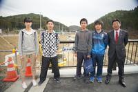 女子生徒1人、男子生徒3人が市長と一緒に並び、「新井田橋」と書かれた橋名板が設置された橋の上で記念撮影をしている写真