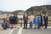 市長と子供達、関係者の方々が「新大森橋」と書かれた橋名板が設置された橋の上で記念撮影をしている写真