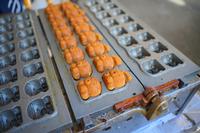 タコの人形焼きが焼かれている写真