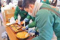 エスビー食品の方が、手のひらサイズの長方形をした容器にオリジナルメニューの料理を盛り付けている写真