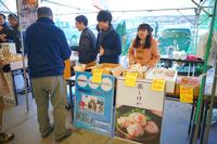 屋台で数人がホヤの商品を販売し、客が購入している様子を写した写真