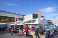 「福興市」と書かれたテントの下で、商品を販売する人たちや、買い物をしている来場者たちを写した写真