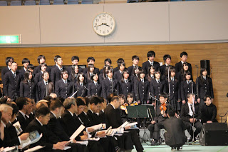 制服姿の志津川高校2年4組のみなさんが壁際に整列し合唱をしている様子を写した写真