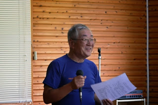 竹内典之先生がマイクを手に持ち話をしている写真