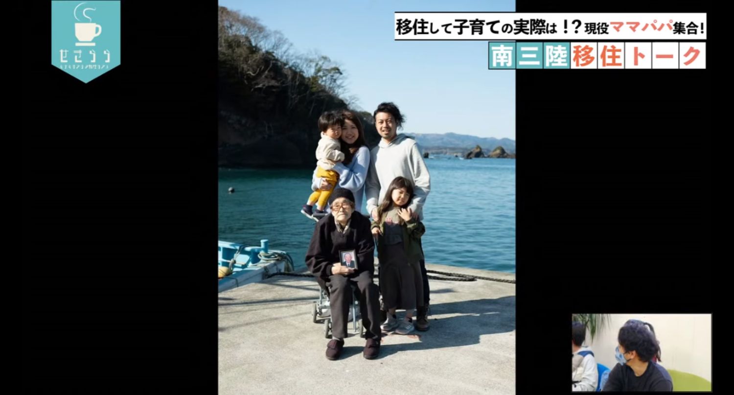 「移住して子育ての実際は！？現役ママパパ集合！南三陸移住トーク」のテーマタイトルが画面右上に表示されており、海の見える桟橋の上で、車椅子に座った高齢者が手に写真を持ち、その後ろに若い夫婦と子ども二人が並んでいる家族の映像と右下のワイプ画像に男性が映っているYouTube LIVE配信番組のスクリーンショットの写真