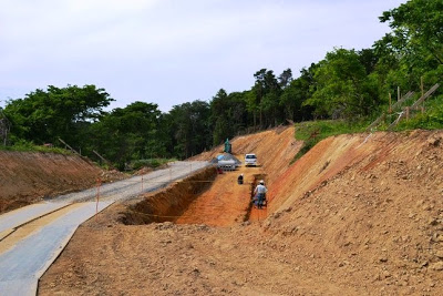両側の土を深く掘削した中で人と重機が作業をしている造成途中の写真
