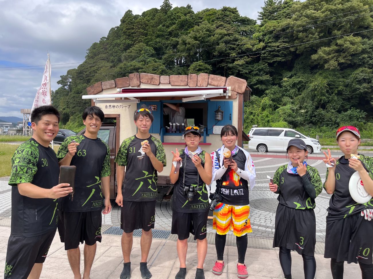 ユニフォーム姿の男女チームがスイーツを手に笑顔で並んだ写真