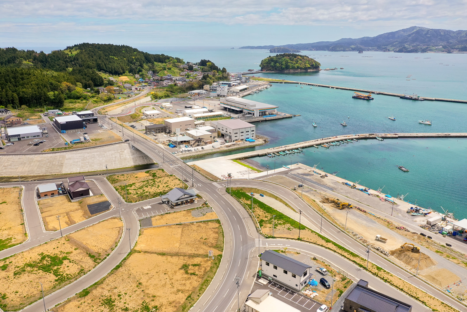 海岸に沿って建物や道路が広がる町を上空から撮影した空撮の写真