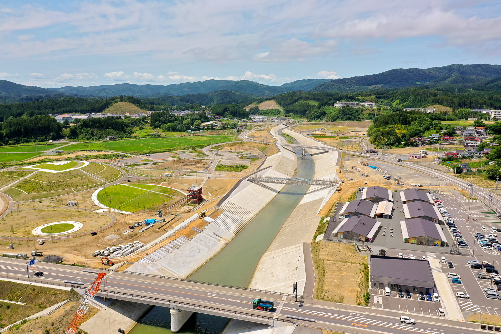 川が広がる風景の中に橋が架かり、周囲には自然が広がっている様子を空から見下ろした川と橋の写真