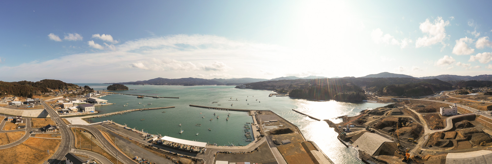 港とその周囲の風景を空から撮影した写真で、海に面した港の構造や周辺の建物、道路などが広がっている様子が見える写真