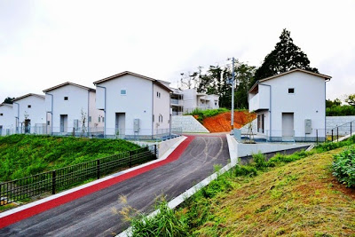 白い外壁の建売住宅が数軒並び、住宅へ上がる坂道の左側が赤い舗装で整えられている新築住宅群の写真