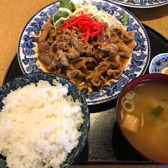 青い柄の大皿に盛られた紅ショウガが乗った肉炒めと千切りキャベツ、白ごはんと味噌汁がセットになっている定食の写真